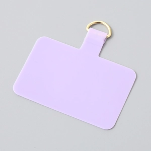 Pale purple TPU phone tether tab with gold D-ring connector on light gray background