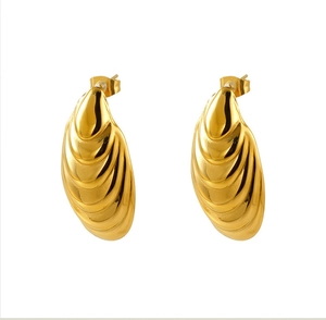 Detail of 18K gold stainless steel shell earrings with ribbed texture and polished finish