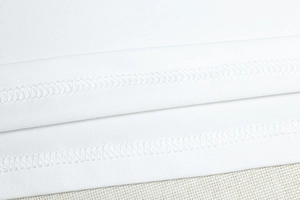 Detail of high-quality double-needle stitching on white dress hemline fabric