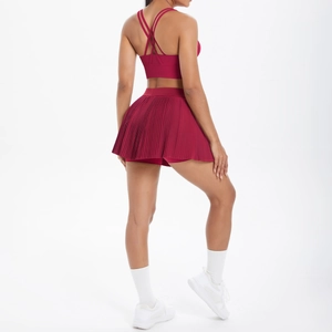 Détail du dos d'une brassière de sport bordeaux et d'une jupe de tennis plissée taille haute