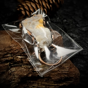 Détail macro du pendentif en agate naturelle avec bord en cuivre sur écorce