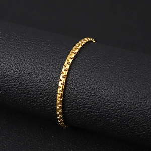 Macro view of polished 18K gold plated stainless steel box chain on black display