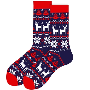 Détail de chaussettes de Noël avec motifs rennes et sapins sur un tissu bleu foncé