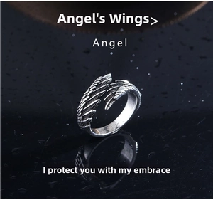 Macro shot of vintage silver angel wing ring showing detailed feather texture and carvings
