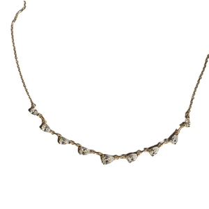 Minimalist gold necklace with eight pear-cut zircon stones in a curved arrangement