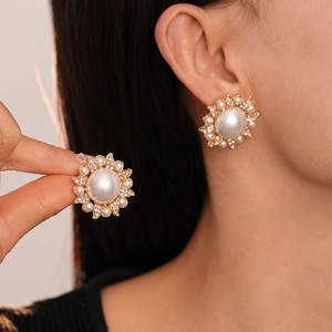 Vintage baroque pearl and rhinestone flower stud earrings shown on model with gold finish