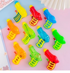 Flat lay of colorful mini plastic water guns for children in vibrant red blue yellow and green
