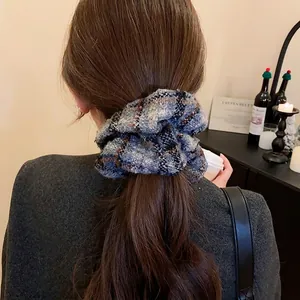 Chouchou en tricot à carreaux bleus porté sur cheveux longs pour un style automnal