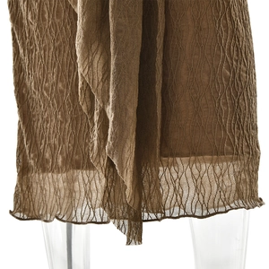 Détail montrant la texture plissée ondulée et l'ourlet irrégulier de la robe marron