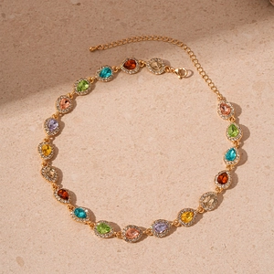 Detail of teardrop gemstones and crystals on a gold chain necklace for women