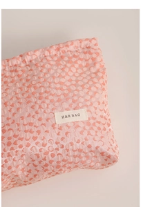 Close-up of pink leopard print cosmetic bag showing fabric texture and H&R brand label