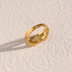 Macro detail of gold stainless steel ring featuring elegant side-set crystal diamond accents