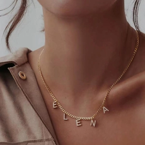 Close-up of golden custom name necklace with sparkling ELENA zircon pendant on a model