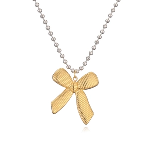 Detail of gold bow pendant with textured surface on a silver-tone ball chain necklace