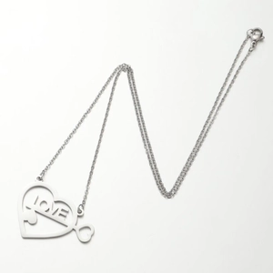 Dettaglio del ciondolo a cuore in acciaio con scritta LOVE e intaglio a forma di puzzle
