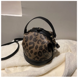 Detail of leopard print cylinder bucket bag with black leather trim and gold hardware