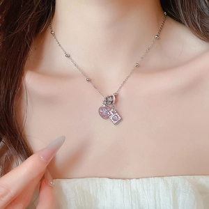 Detail view of Tarot-style heart and square pendants on a delicate silver necklace