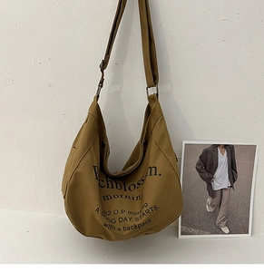 Détail de la bandoulière réglable et de la boucle en métal du sac fourre-tout en toile kaki