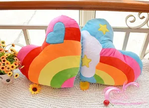 Detailed embroidery of heart, star, and cloud patterns on plush rainbow pillows