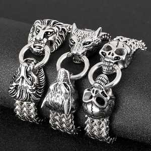 Punk style stainless steel bracelets with lion, wolf, and skull charms on display stand