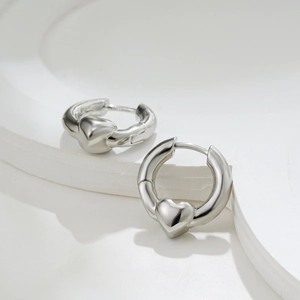 Detail view of silver heart hoop earrings showing polished finish and sleek metal design