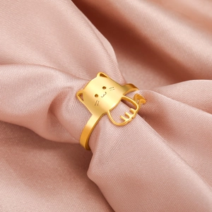 Golden minimalist cat-shaped ring with paw details on soft pink satin fabric