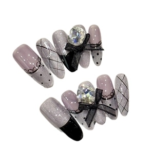 Silver glitter press-on nails with black lace patterns and 3D bow rhinestone accents