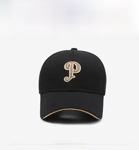 Détail d'une casquette noire avec lettre P brodée dorée et liseré sur la visière