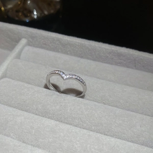 Macro shot of V-shaped silver ring featuring pave set cubic zirconia on a gray holder