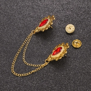 Detailed view of vintage gold collar pin set with red teardrop gems and double chains