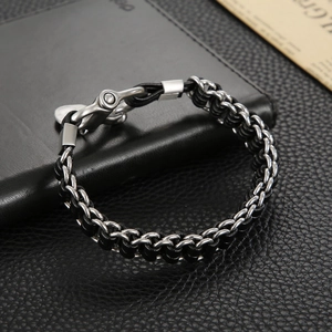 Détail du bracelet tressé en cuir noir pour homme avec boucle en métal argenté