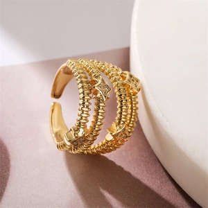 Macro detail of gold adjustable ring featuring triple wavy bands and zircon-set star charms