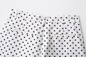 Dettaglio degli shorts a pois con tasche posteriori, passanti per cintura e cuciture