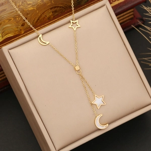 Golden moon and star layered necklace with shell inlay on a beige jewelry display box