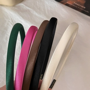 Close-up of colorful satin sponge headbands in green, rose, and coffee colors
