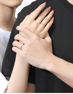 Close-up of elegant V-shaped silver engagement ring with sparkling stones for couples
