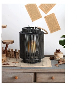 Detail view of a Nordic hand-woven black bamboo lantern with rope handle and white candle
