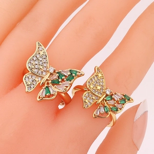 Detailed view of butterfly ring with green and white zircons on a golden band