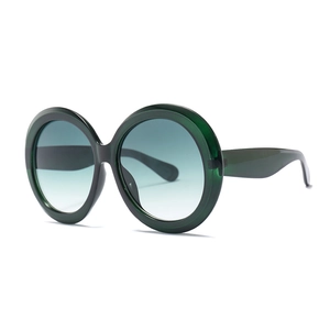 Oversized round sunglasses with translucent dark green frame and gradient blue lenses