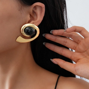 Retro geometric gold spiral earrings with black oval resin stone worn by model