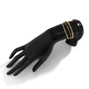 Detailed view of three-piece gold snake and cuban link chain bracelet set on black hand model
