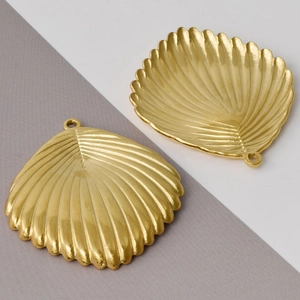 Detail of two golden shell-shaped 304 stainless steel pendants for DIY necklace making