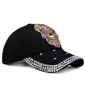 Black baseball cap featuring sugar skull embroidery and sparkling rhinestone embellishments