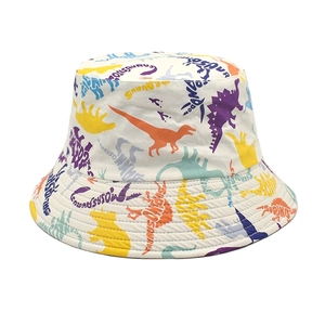 Detail shot of white bucket hat with colorful cartoon dinosaur prints and reinforced stitching