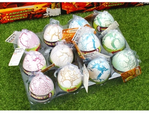Tray of 12 magic growing dinosaur eggs in pink, white, and green on a grass lawn