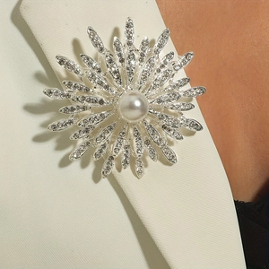 Elegant rhinestone flower brooch with center pearl on a beige suit blazer lapel