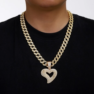 Iced out heart pendant necklace with gold cuban chain shown on a model for hip hop fashion