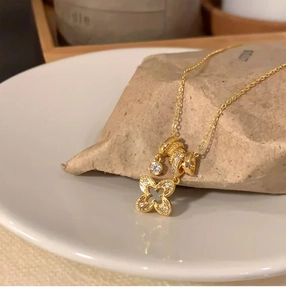 Close-up of gold flower pendant with white zircon stones and decorative beads