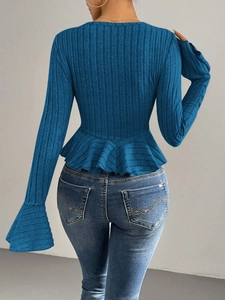 Detail of blue ribbed knit top showing back fit and ruffled hemline with lettuce edges