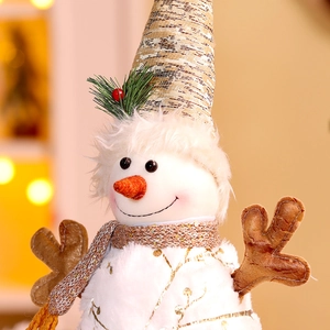 Detailed close-up of plush snowman ornament with gold hat and textured carrot nose